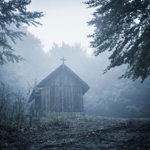 Old church in forest with fog
