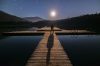 Man on dock with long shadow caused by moon
