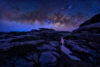 Starry sky over canyon with water