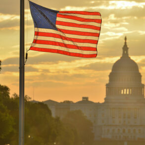 U.S. flags with U.S. Capitol in background, at sunset
