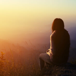 Soft silhouette of woman with early morning vista