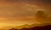 Hills with smoke and orange sky