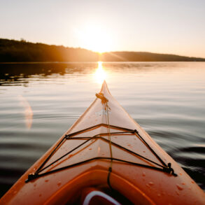 Sea kayak pointed into sunset over islands