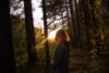 Silhouette of woman in woods at sunrise