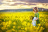 Young girl in field of flower mustard
