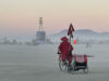Monk on bicycle at Burning Man at twilight