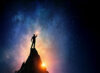 Silhouette of man on peak with stars