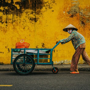 Woman pushing cargo through old town of Hoi An