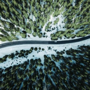 Aerial of road in winter with forest