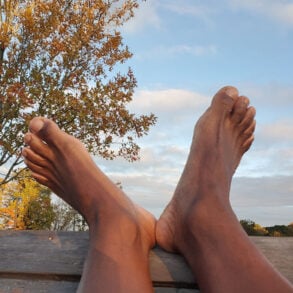 Black feet on fence railing