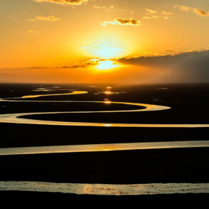 Winding river reflected in sunset