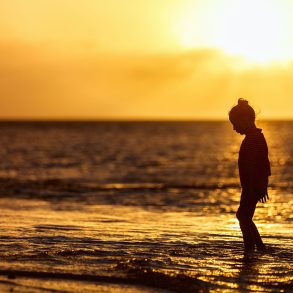 Silhouette of girl at beach at sunset