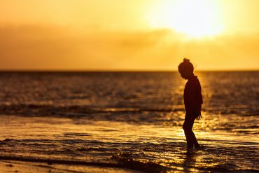 Silhouette of girl at beach at sunset